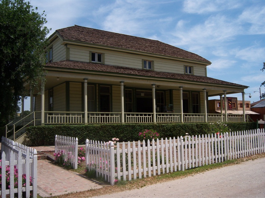 Sample large farmhouse-style home with a wraparound porch